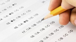 Hand completing a multiple choice exam.